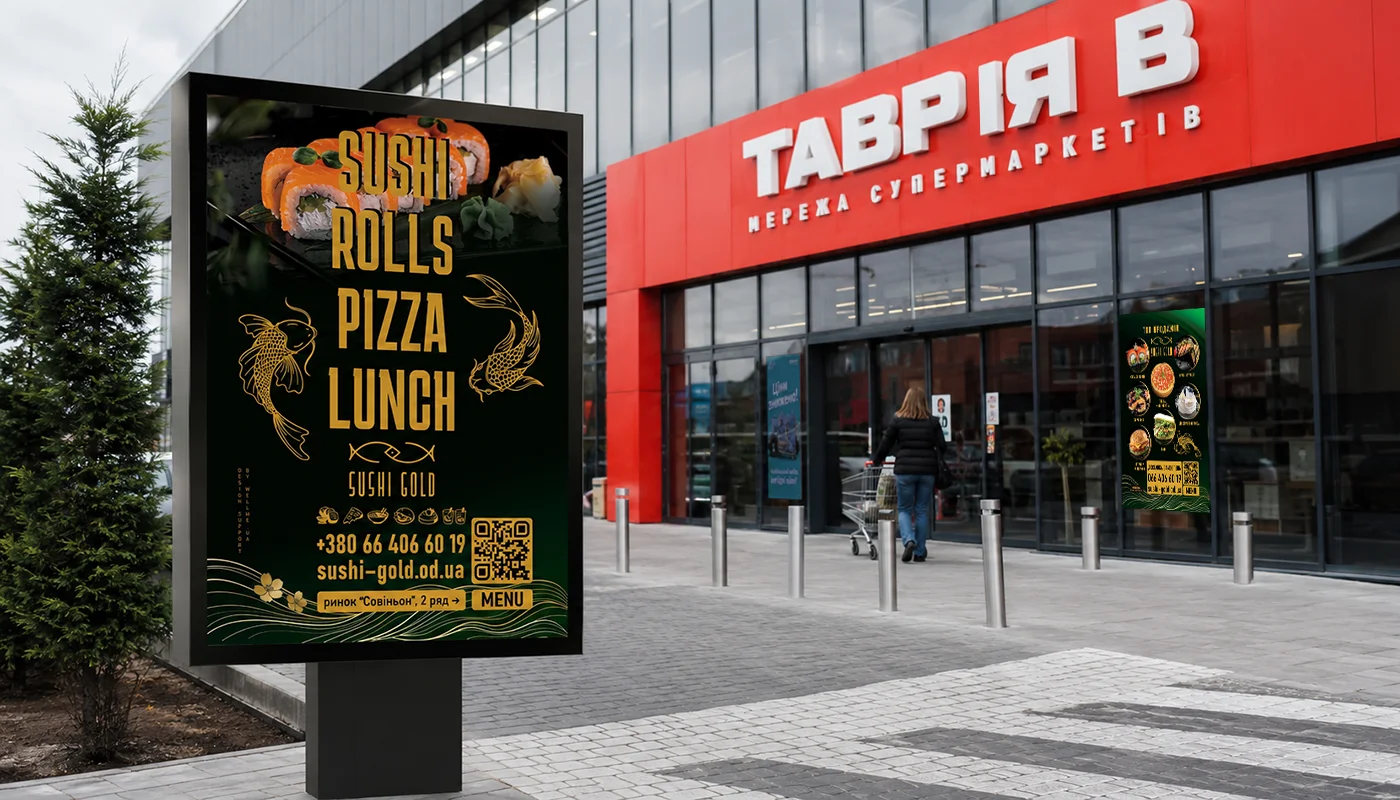 Sushi Gold — street-side lightbox outside the Tavria V supermarket: rolls, pizza and lunch, with the phone number, site address and a QR code to the menu